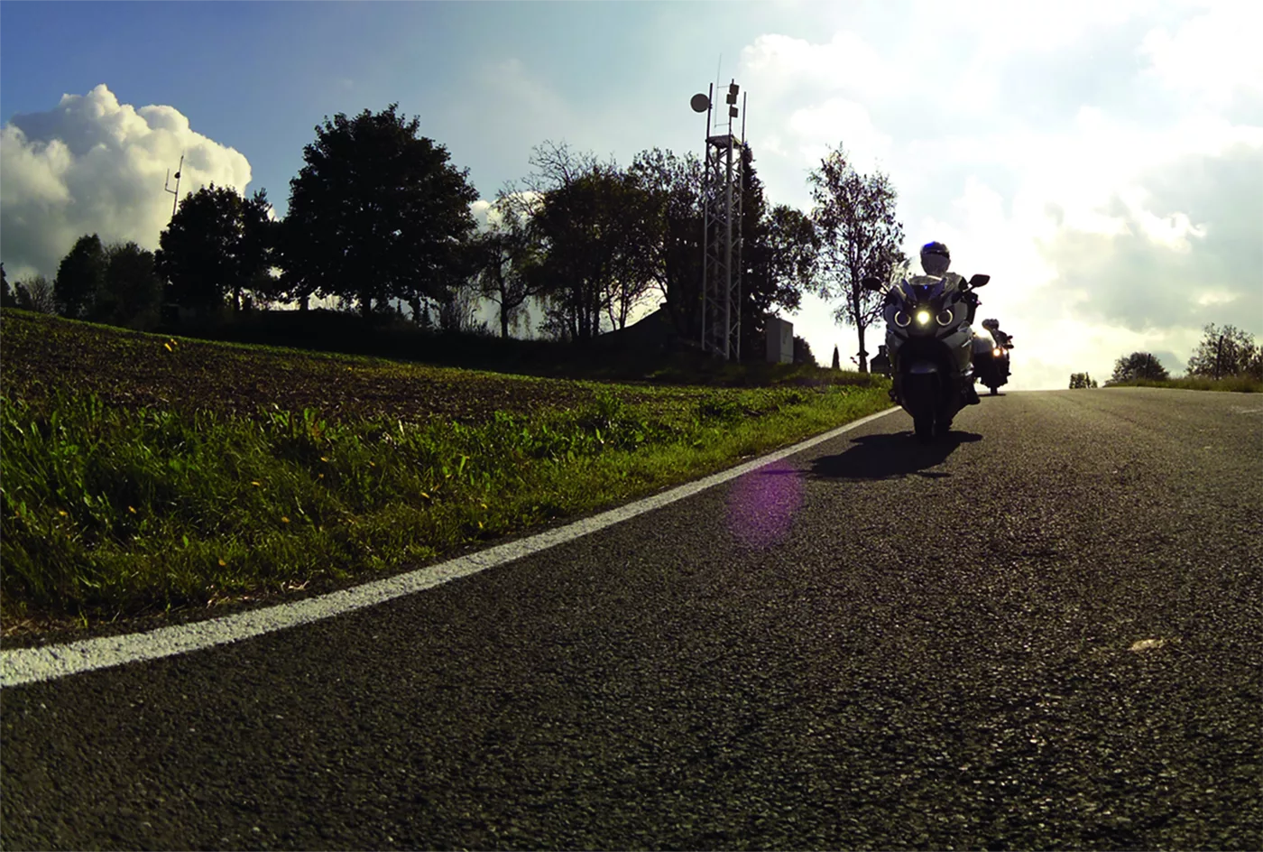 Motorrad auf einer Landstraße im tiefstehenden Abendlicht